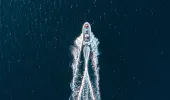 Aerial view of small boat with a trail of wash